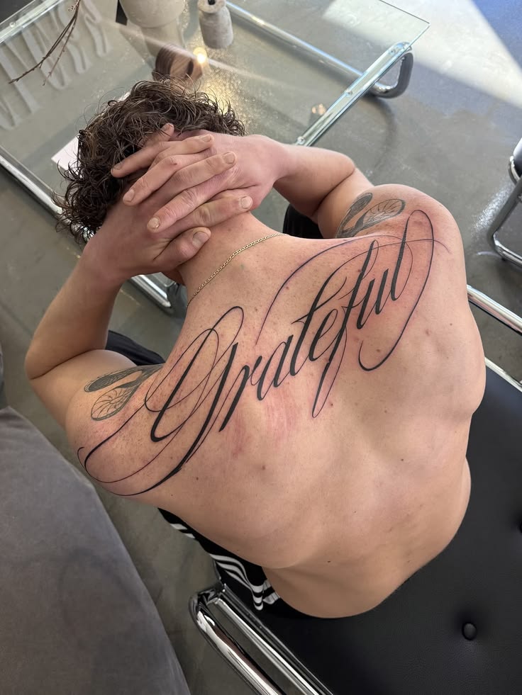 Kaligraficzny tatuaż letteringowy na plecach